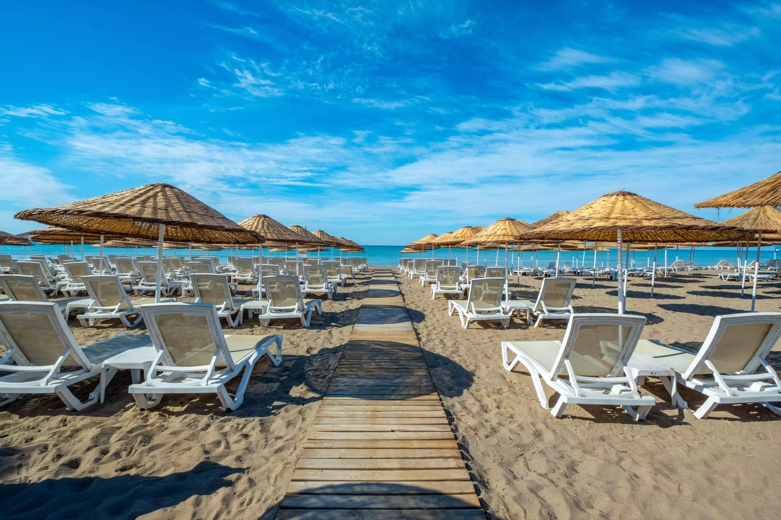 Private beach with sun loungers and straw umbrellas